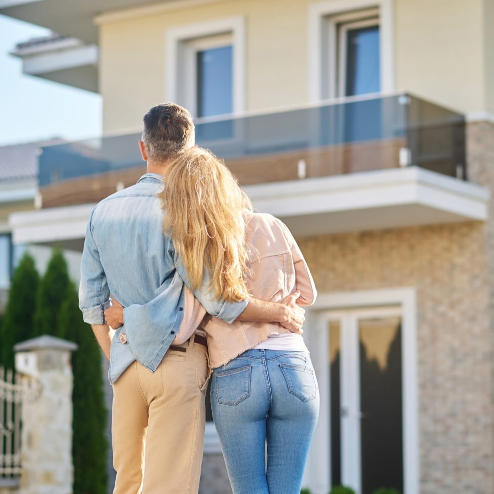 happy-moment-rear-view-man-long-haired-woman-casual-clothes-looking-their-new-home-fine-afternoon